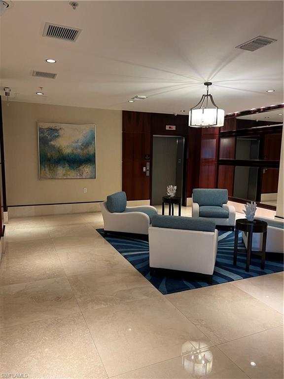265 Indies Way, Unit 701 Naples, FL 34110 - Photo 34 of 36 a living room with furniture and a chandelier