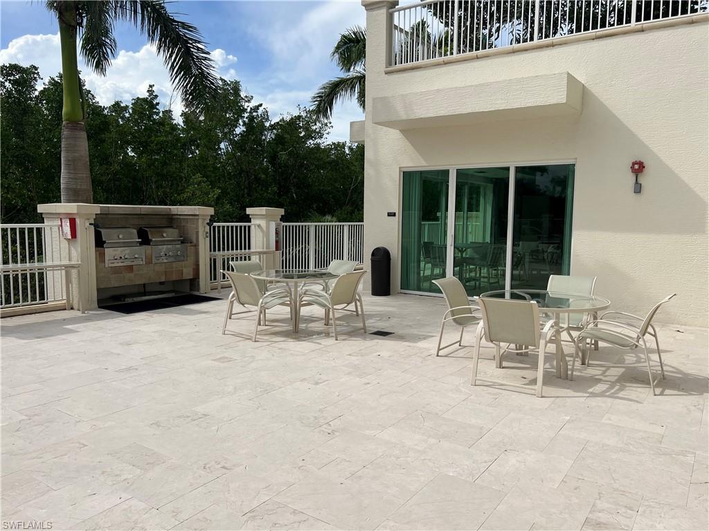 265 Indies Way, Unit 701 Naples, FL 34110 - Photo 35 of 36 a view of table and chairs in patio