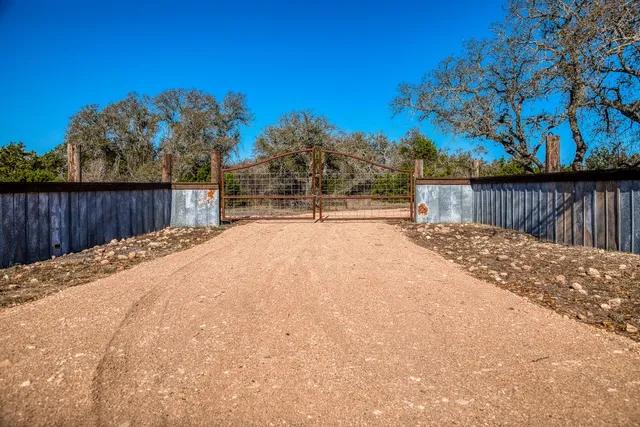 a swimming pool with an outdoor space and trees in the background