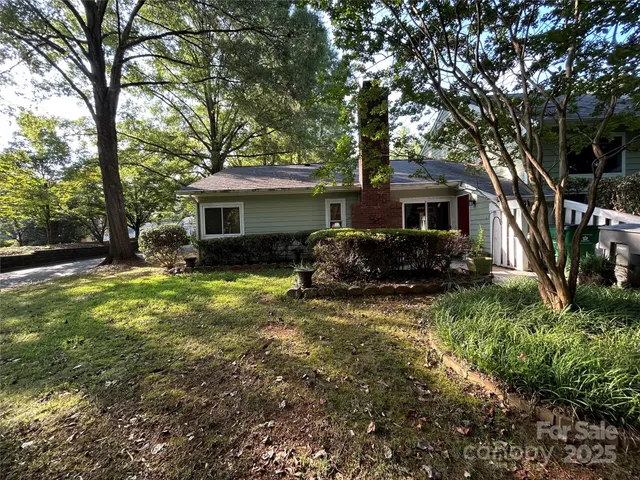a front view of house with yard and trees around