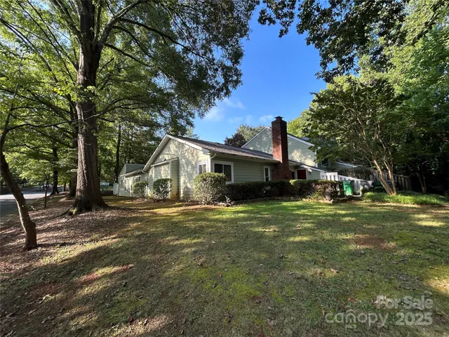 a front view of a house with a garden and trees