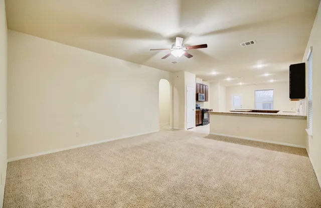 a view of an empty room with a kitchen