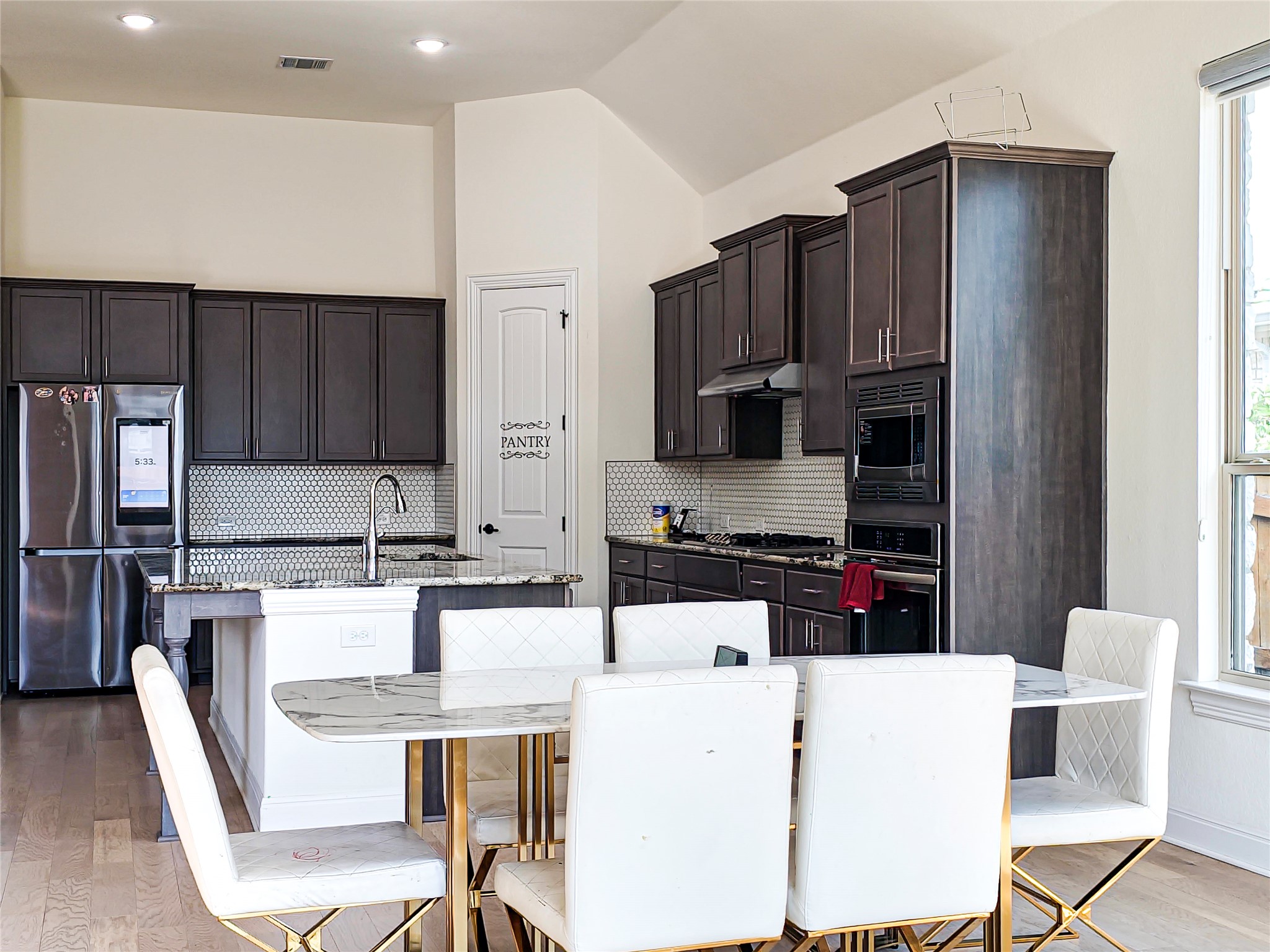 813 Sunny Ridge Drive Leander, TX 78641 - Photo 15 of 32 Culinary aspirations meet sophisticated design in this kitchen, featuring integrated appliances and an inviting island.