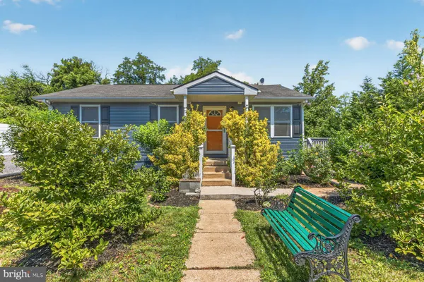 a front view of a house with a yard and potted plants