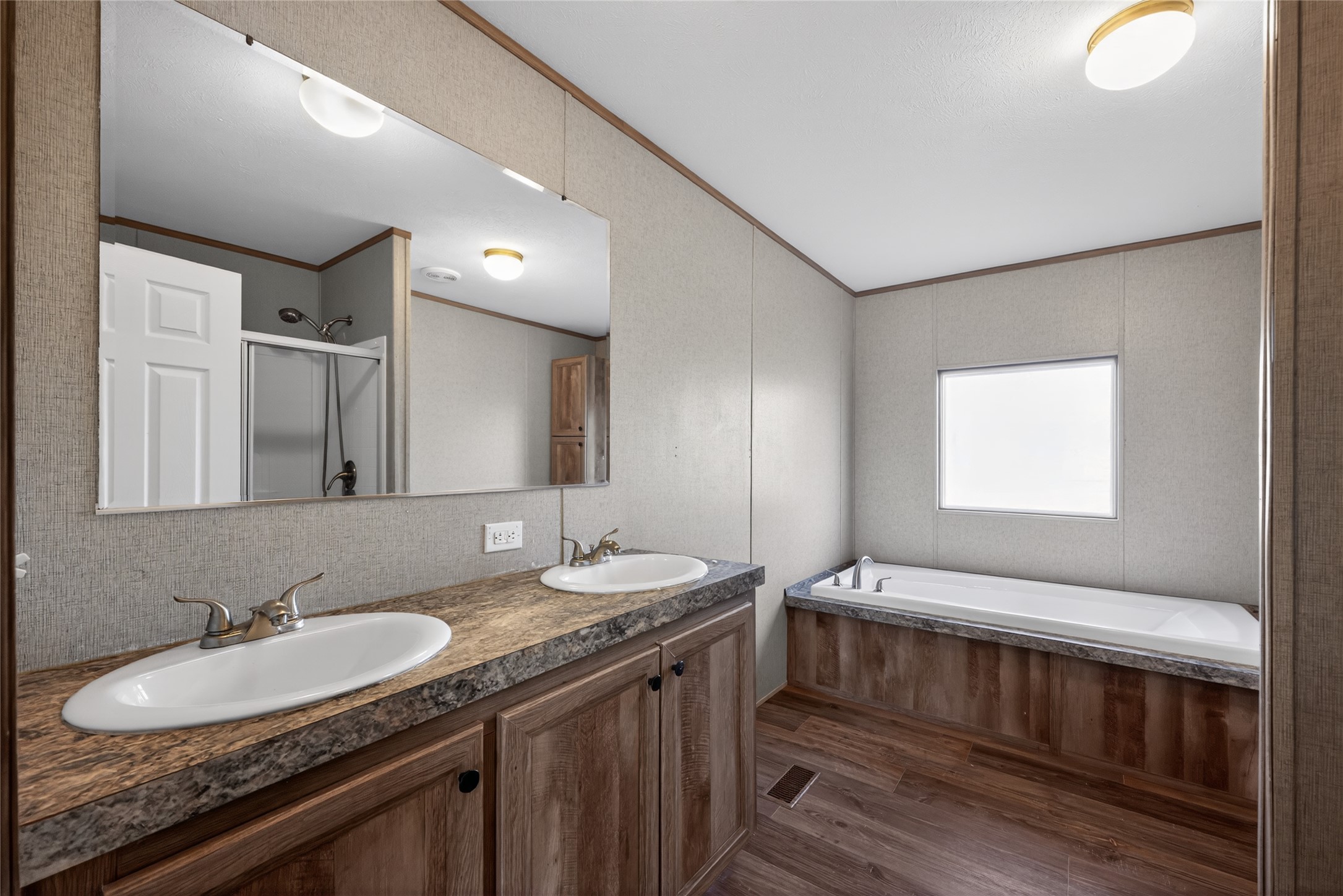 2674 Cotton Gin Road Kyle, TX 78640 - Photo 28 of 30 Bathroom with double vanity, crown molding, dark wood-style floors, a garden tub, and a stall shower