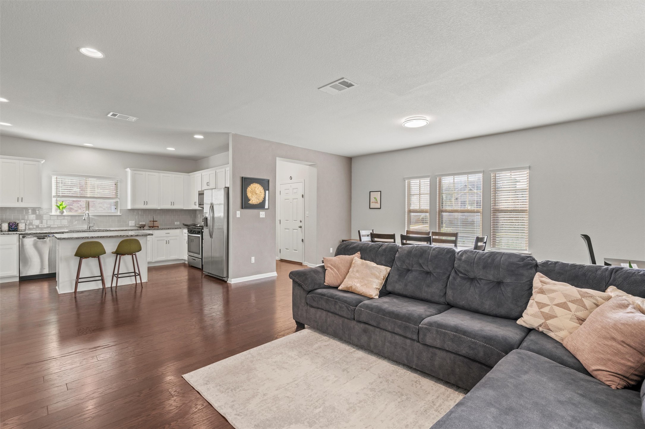 Living room featuring dark wood finished floors, recessed lighting, and visible vents