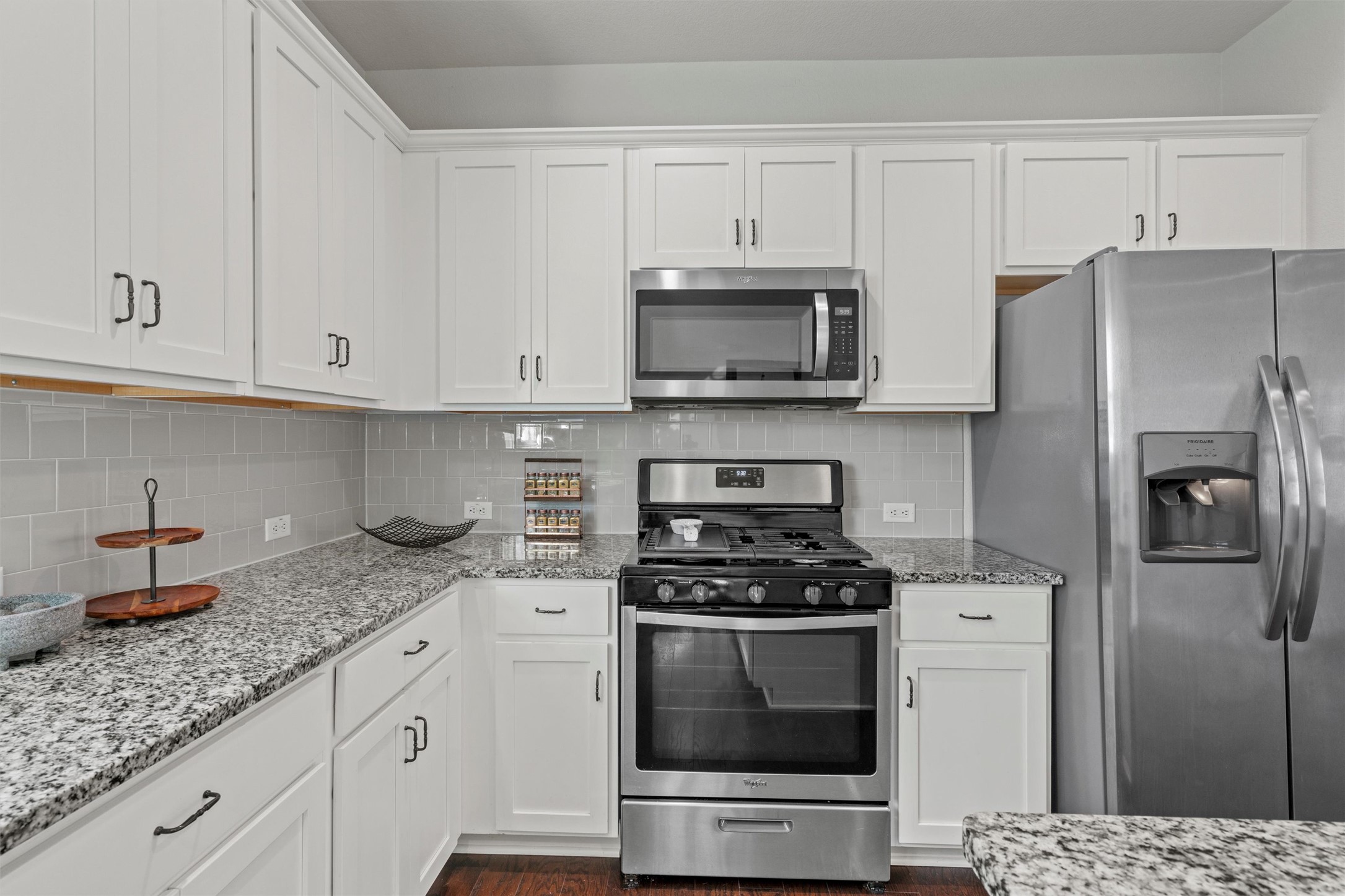 8144 Daisy Cutter Crossing Georgetown, TX 78626 - Photo 11 of 40 Kitchen with white cabinetry, light stone counters, decorative backsplash, and appliances with stainless steel finishes