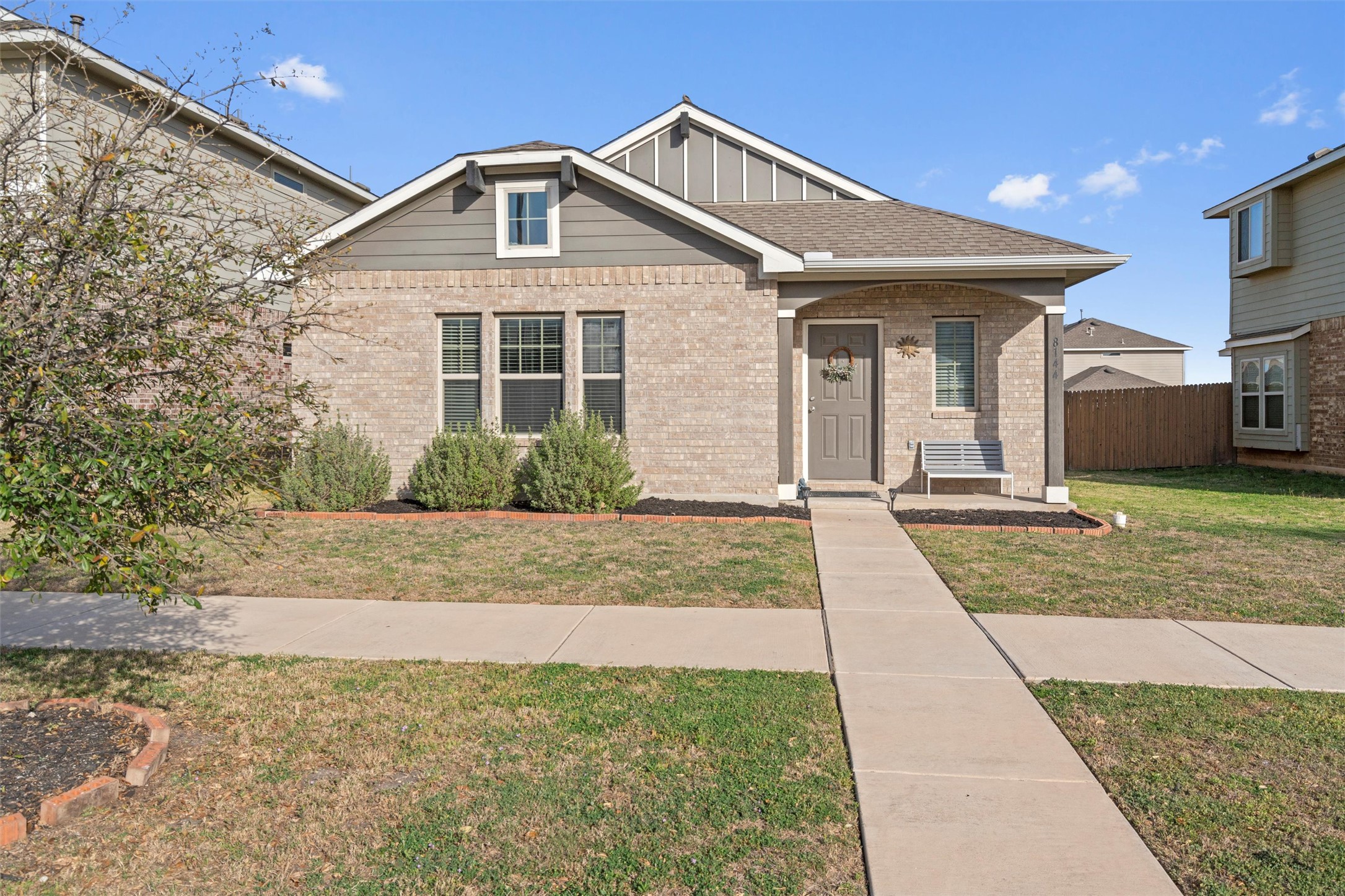 8144 Daisy Cutter Crossing Georgetown, TX 78626 - Photo 2 of 40 View of front facade with board and batten siding, brick siding, fence, and a front lawn