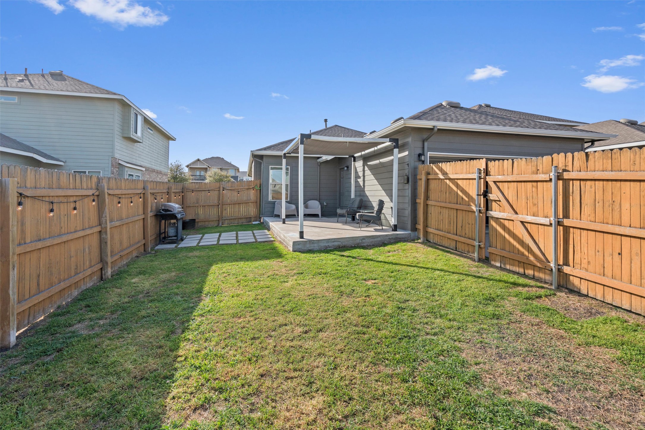 8144 Daisy Cutter Crossing Georgetown, TX 78626 - Photo 27 of 40 Back of house with a gate, a fenced backyard, roof with shingles, a yard, and a patio area
