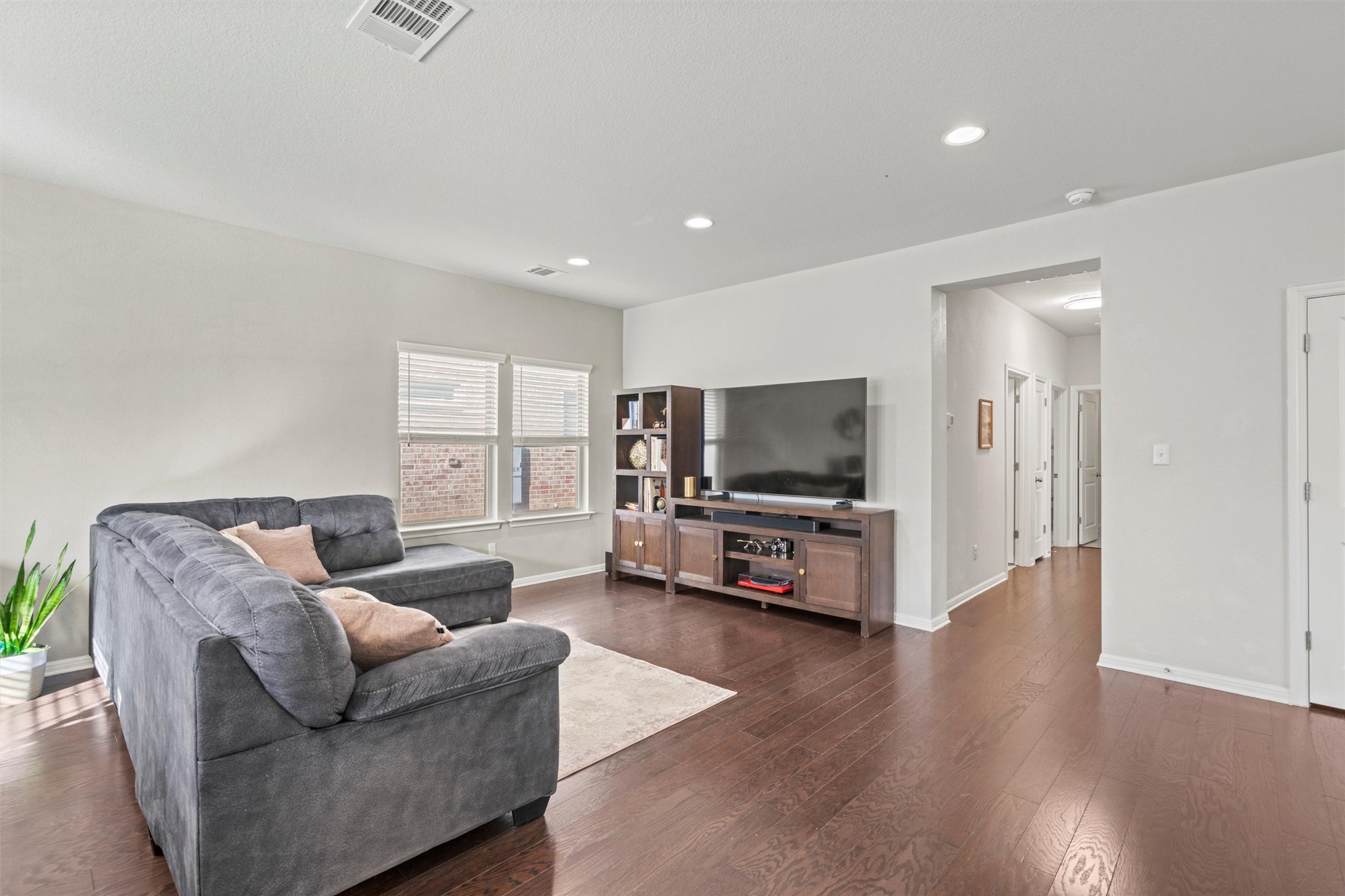 8144 Daisy Cutter Crossing Georgetown, TX 78626 - Photo 4 of 40 Living room featuring baseboards, dark wood-style floors, visible vents, and recessed lighting