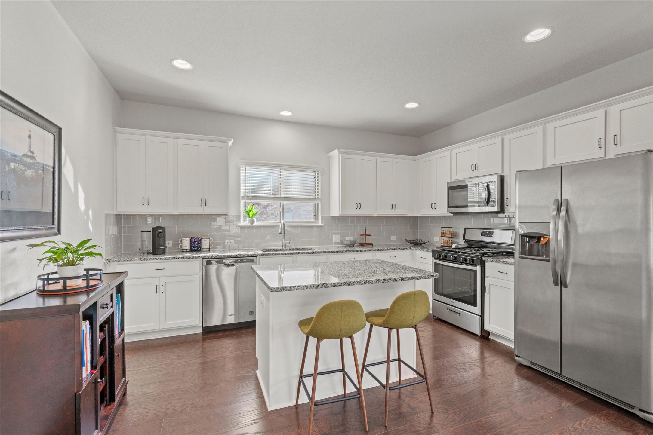 8144 Daisy Cutter Crossing Georgetown, TX 78626 - Photo 8 of 40 Kitchen featuring dark wood finished floors, a sink, stainless steel appliances, and decorative backsplash