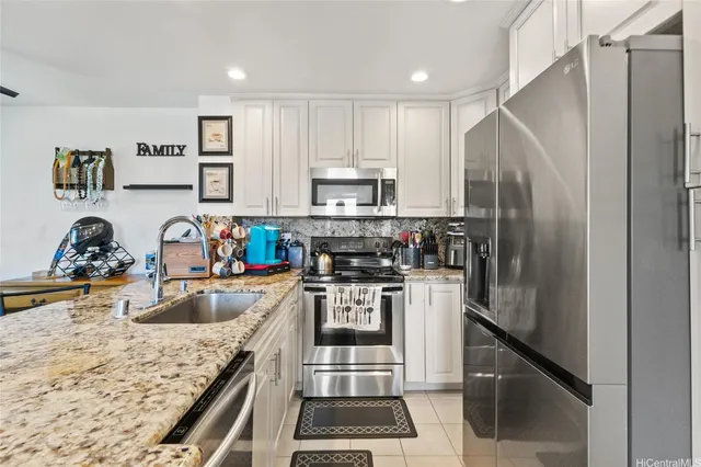a kitchen with a refrigerator sink and cabinets
