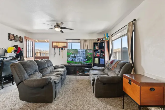 a living room with furniture a flat screen tv and a window