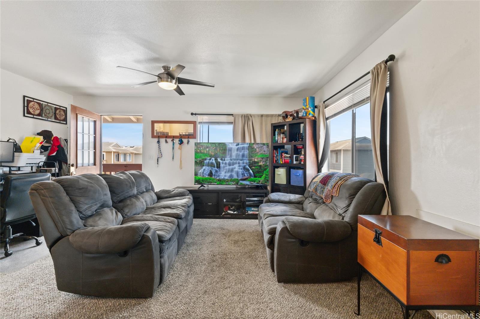 91-1010 Huliau Street, Unit 5C Ewa Beach, HI 96706 - Photo 5 of 16 a living room with furniture a flat screen tv and a window