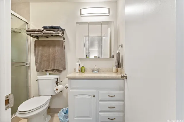 a bathroom with a granite countertop toilet sink and mirror