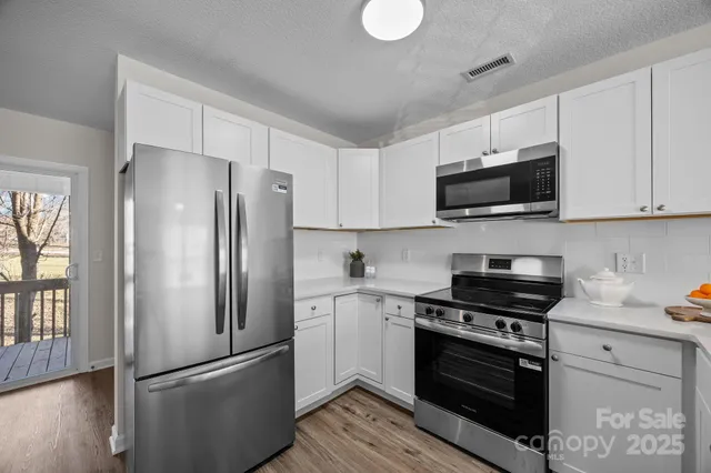 a kitchen with stainless steel appliances a refrigerator stove and microwave