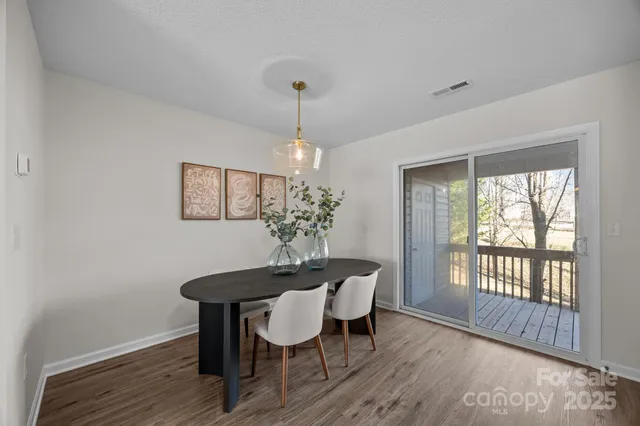 a dining room with furniture a chandelier and wooden floor