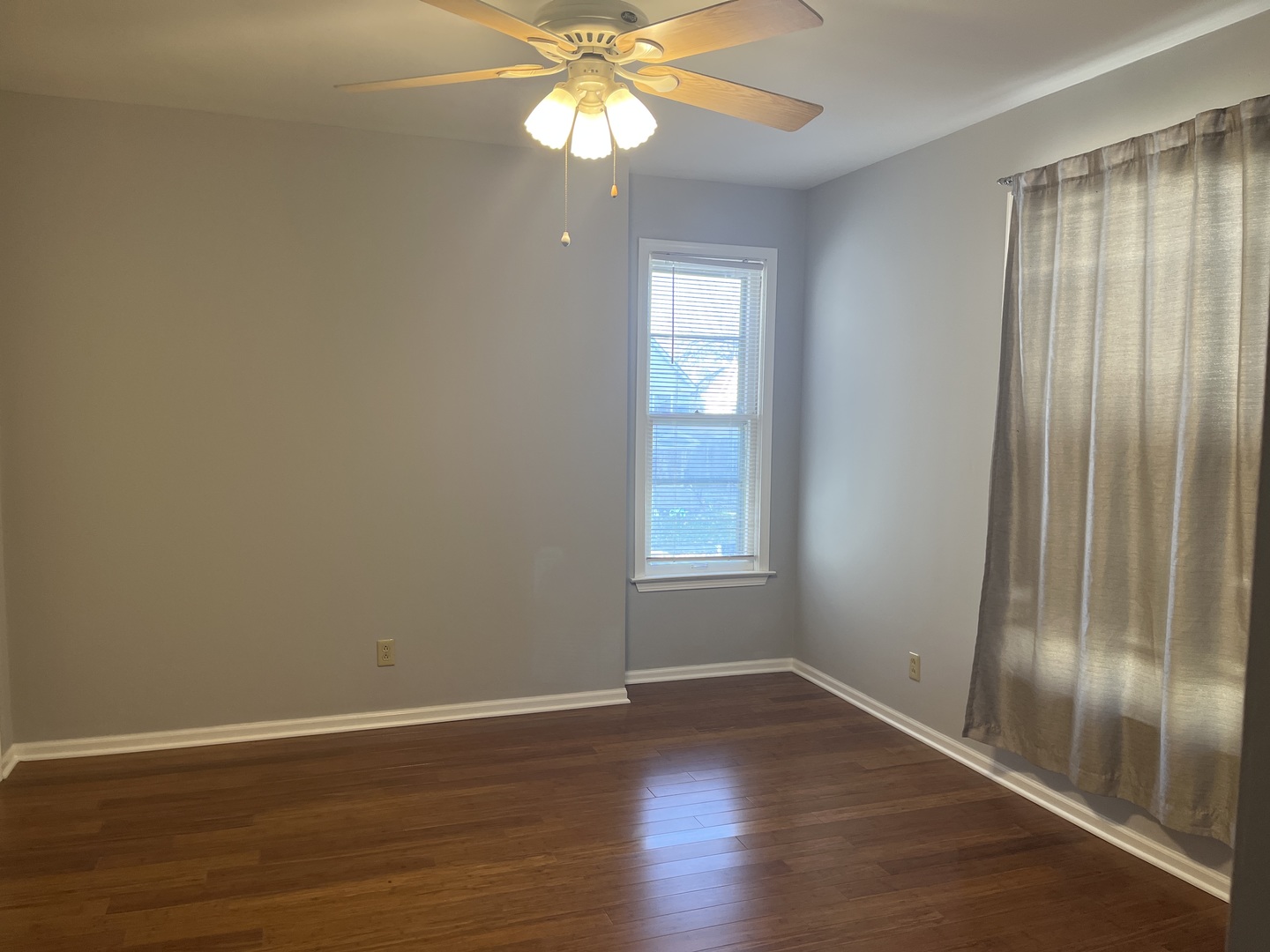 305 North View Street, Unit 2 Aurora, IL 60506 - Photo 2 of 9 an empty room with wooden floor fan and windows