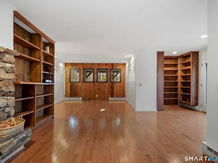 a view of an empty room with wooden floor and closet