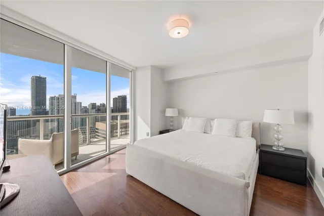 a bedroom with a large bed and glass door