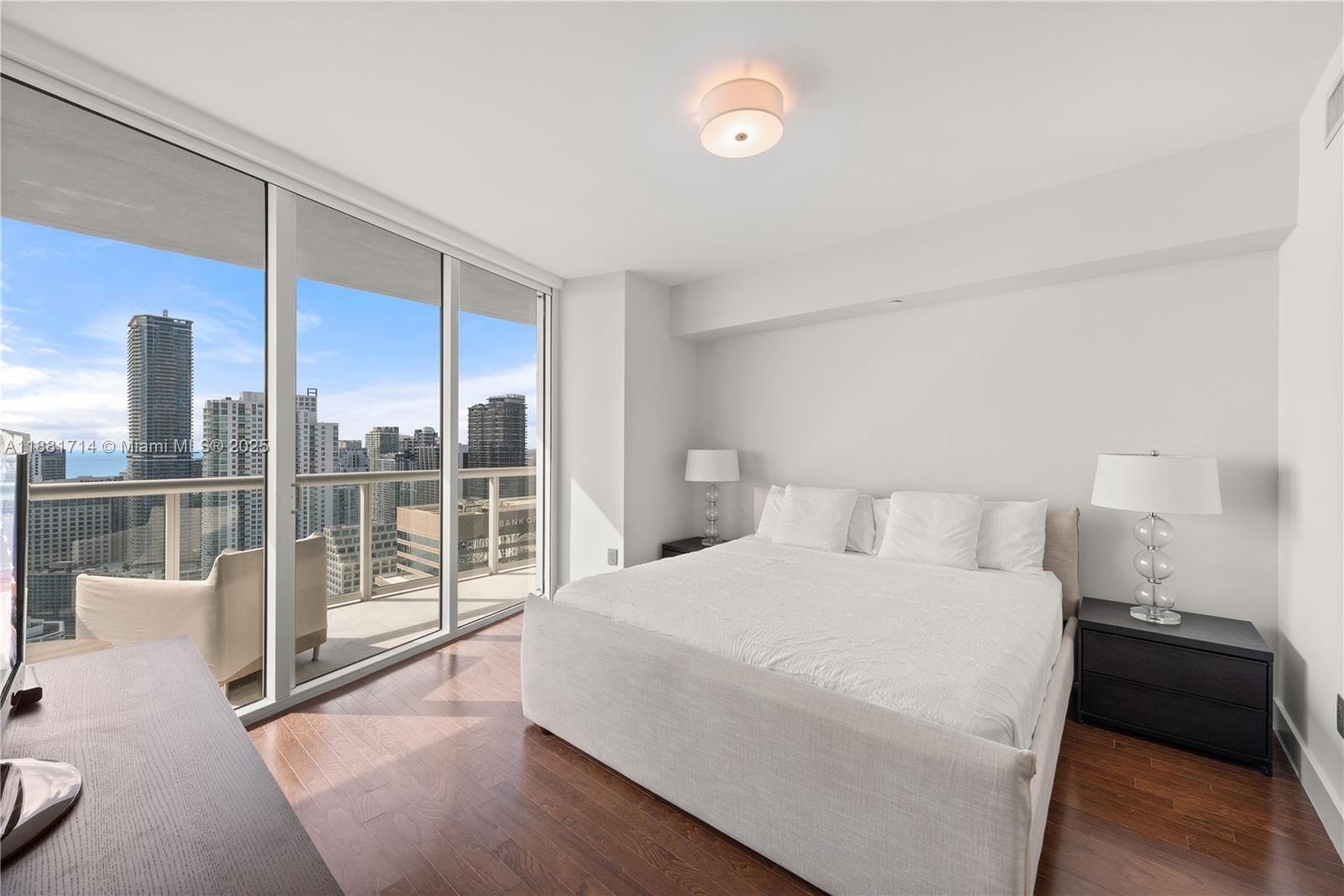 495 Brickell Avenue, Unit 5003 Miami, FL 33131 - Photo 10 of 21 a bedroom with a large bed and glass door
