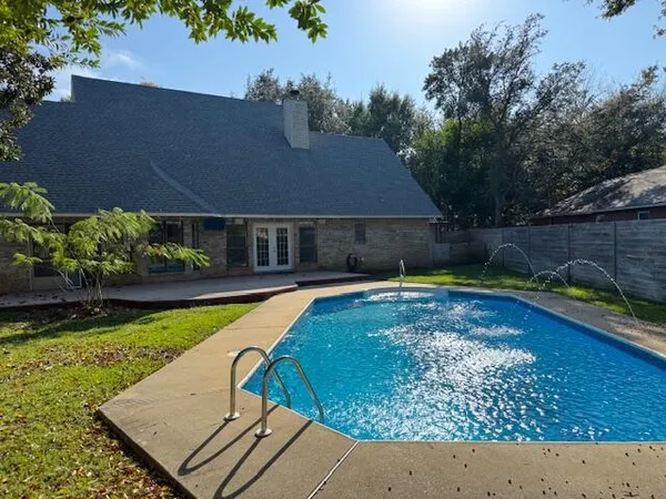 a view of a house with swimming pool and a yard