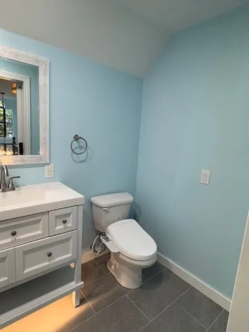 a bathroom with a toilet a sink and mirror