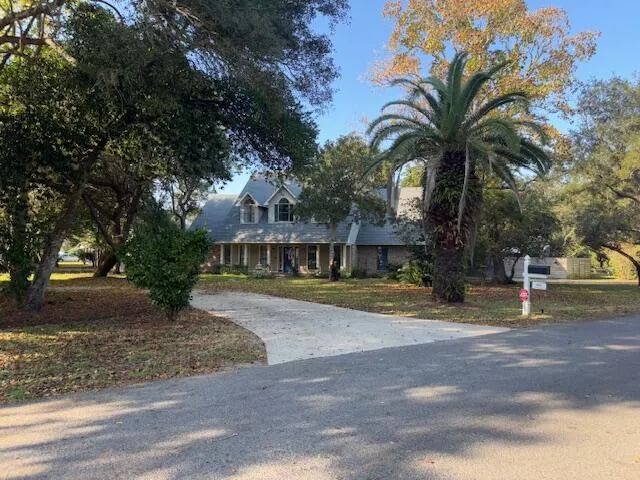 a view of a house with a yard and large tree
