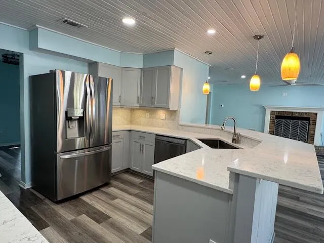 a kitchen with stainless steel appliances granite countertop a sink a refrigerator and a stove