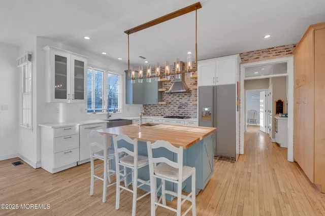 a kitchen with stainless steel appliances granite countertop a sink and a refrigerator