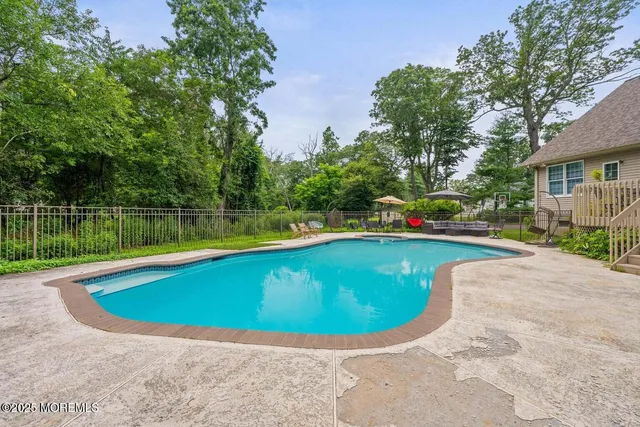 a view of swimming pool with seating area and garden