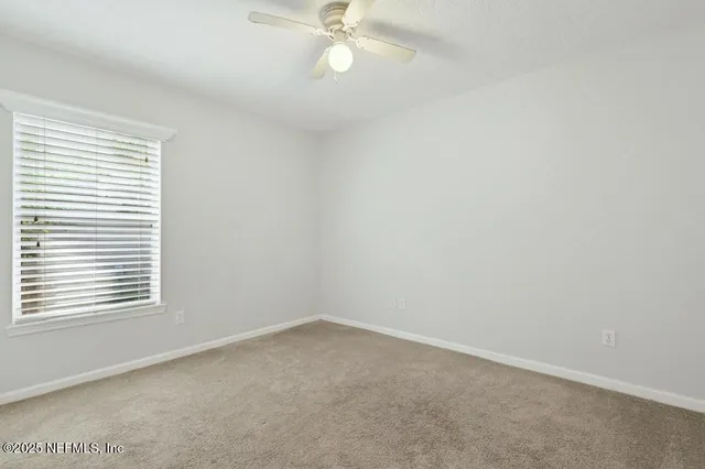 an empty room with wooden floor and chandelier fan