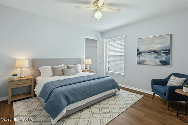 a view of an empty room with wooden floor fireplace and a window