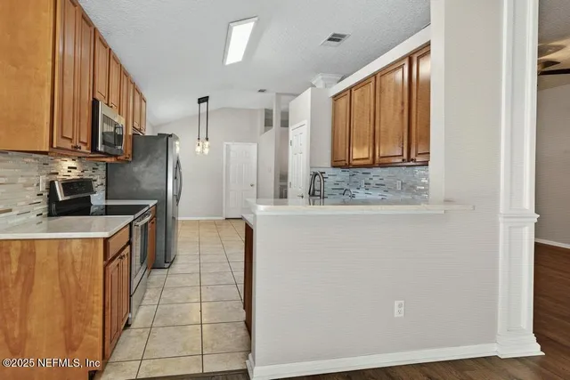 a kitchen with stainless steel appliances kitchen island granite countertop a refrigerator and a sink