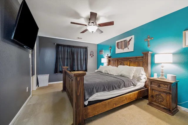 a bedroom with a bed and a flat tv screen on dresser