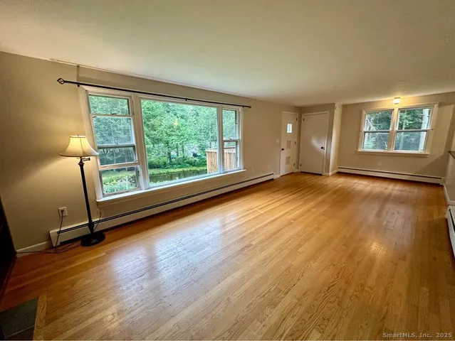 a view of a room with wooden floor and window