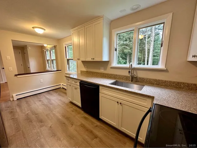 a kitchen with granite countertop a sink and a refrigerator