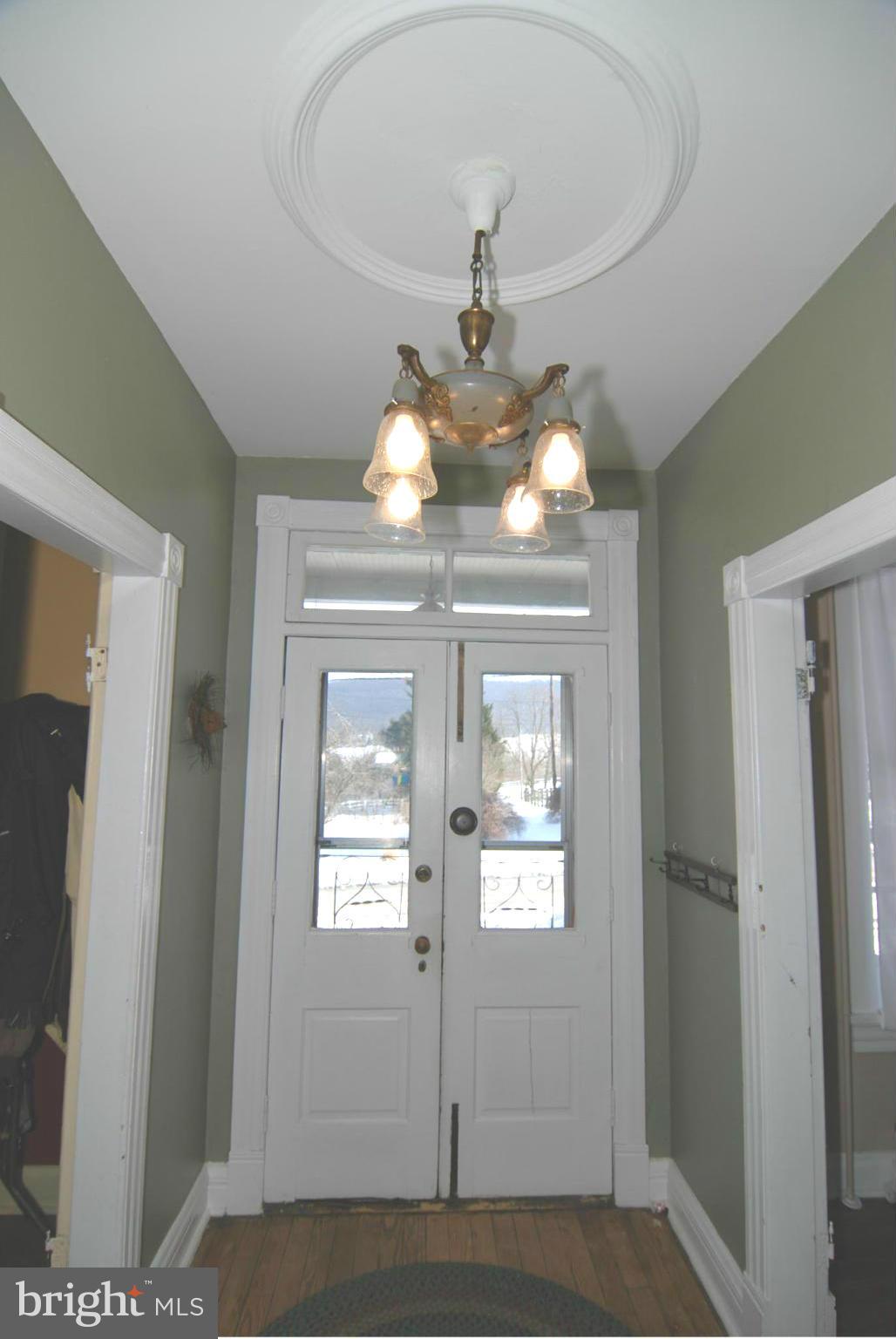 4256 Main Street Rohrersville, MD 21779 - Photo 8 of 26 a view of a hallway with wooden floor and chandelier