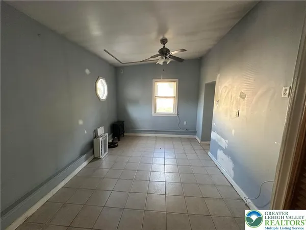 en empty room with windows and ceiling fan