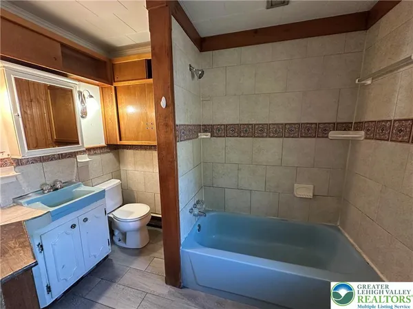 a bath room with a toilet a bath tub and a sink