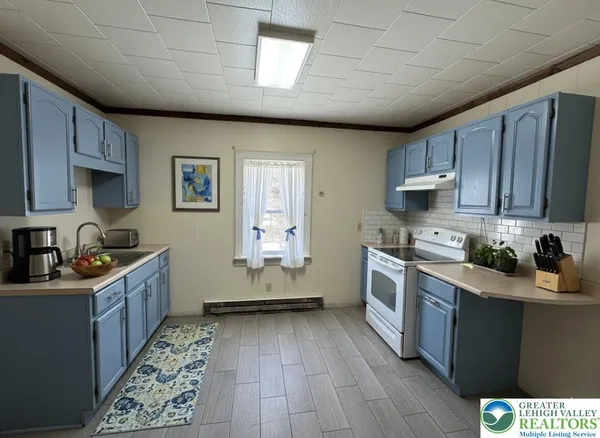 a kitchen with sink a stove and cabinets