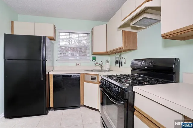a kitchen with stainless steel appliances a refrigerator a sink and a stove