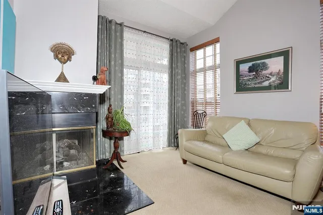 a living room with furniture a fireplace and a large window