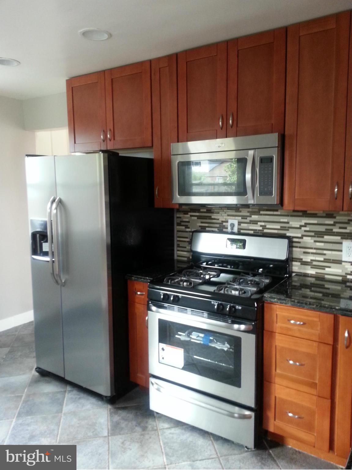3800 Randolph Road Silver Spring, MD 20902 - Photo 10 of 23 a kitchen with wooden cabinets and stainless steel appliances