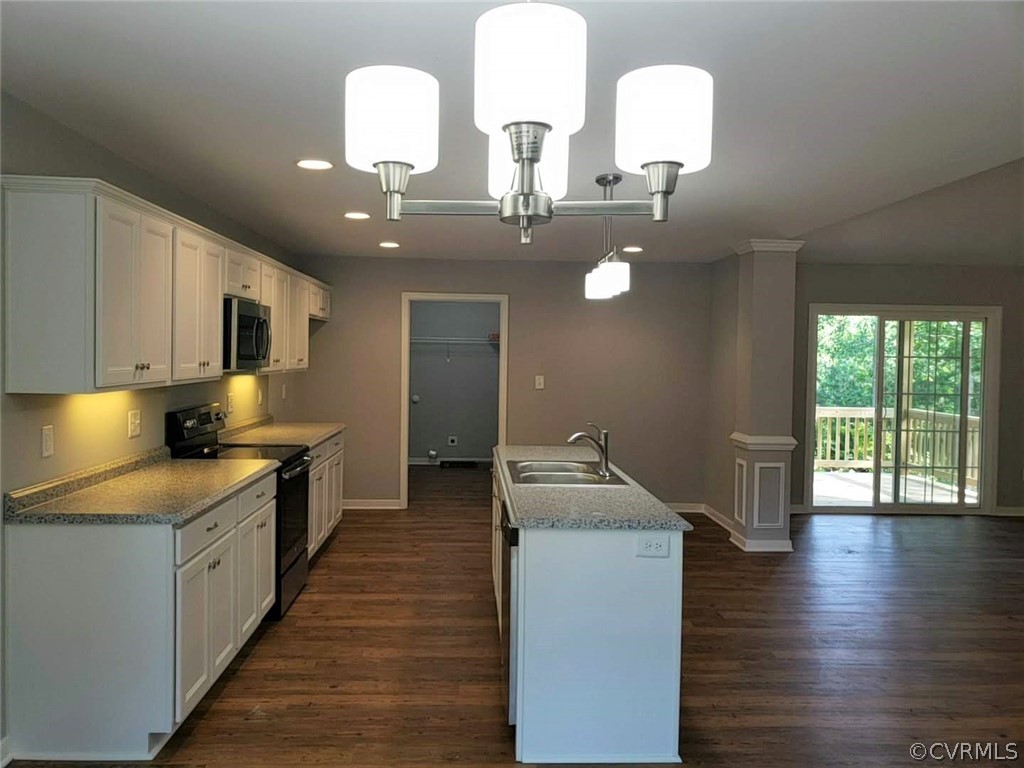 9202 Hunters Trail Road Petersburg, VA 23803 - Photo 8 of 17 a kitchen with stainless steel appliances granite countertop a sink dishwasher a stove a dining table and chairs with wooden floor