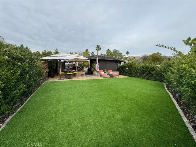 a view of a house with a yard and sitting area