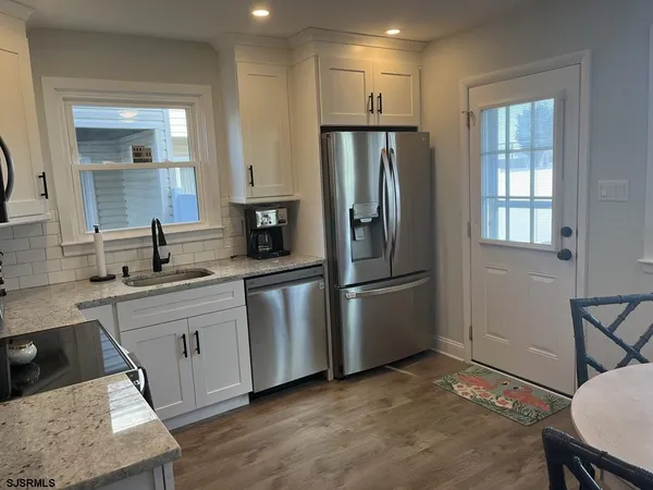 a kitchen with white cabinets and stainless steel appliances
