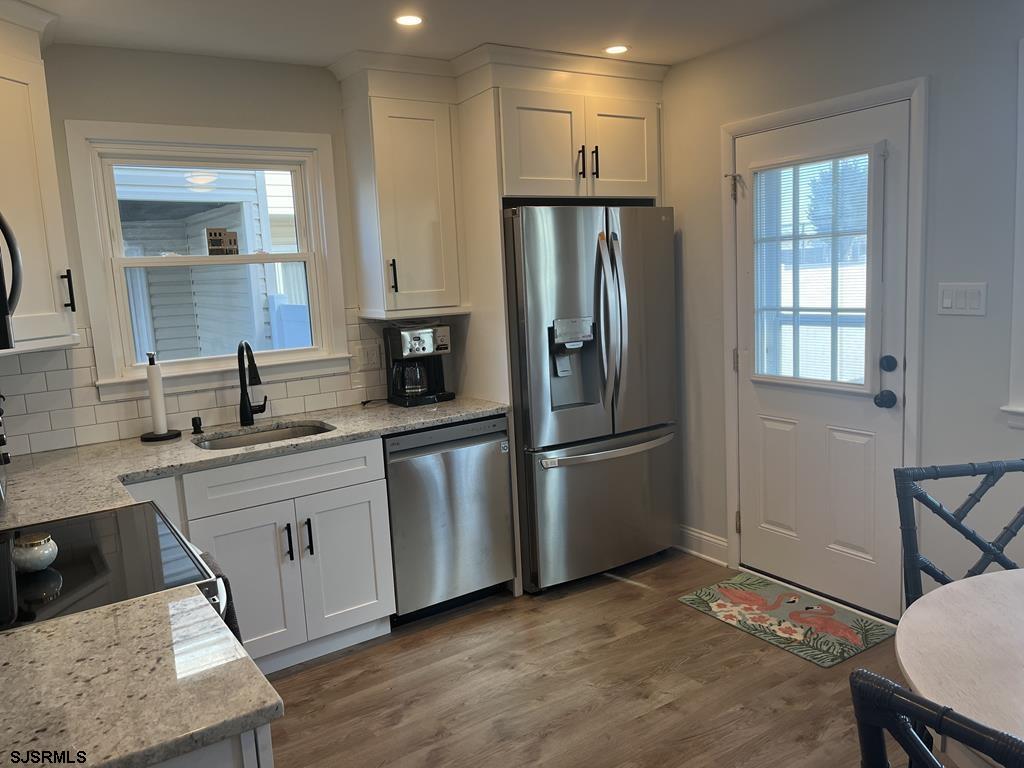 136 44th Street South, Unit A Brigantine, NJ 08203 - Photo 13 of 19 a kitchen with white cabinets and stainless steel appliances