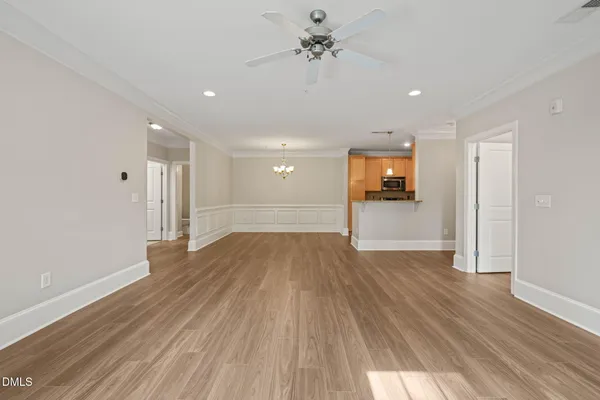a view of a big room with wooden floor and windows