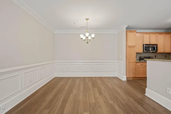 a view of a room with wooden floor and electronic appliances